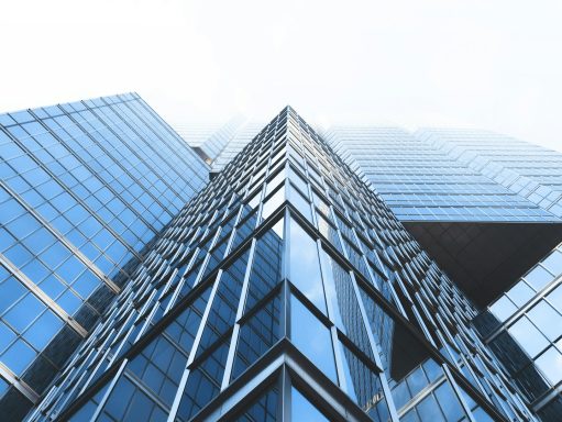 Blick von unten auf moderne Glasgebäude, die in den Himmel ragen.